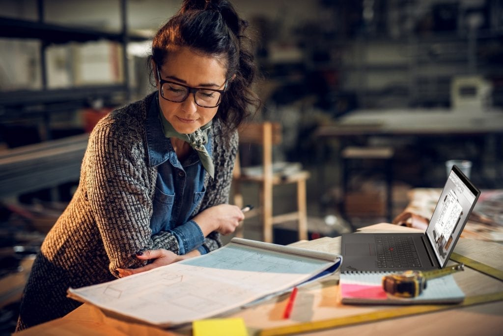 Woman with architectural drafting pads working with a Lenovo ThinkPad P1 Gen 4