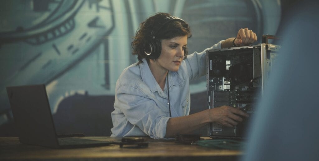 Woman working with an open desktop PC and ThinkPad