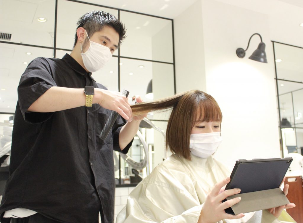 Japan salon with someone using a tablet while getting their hair cut