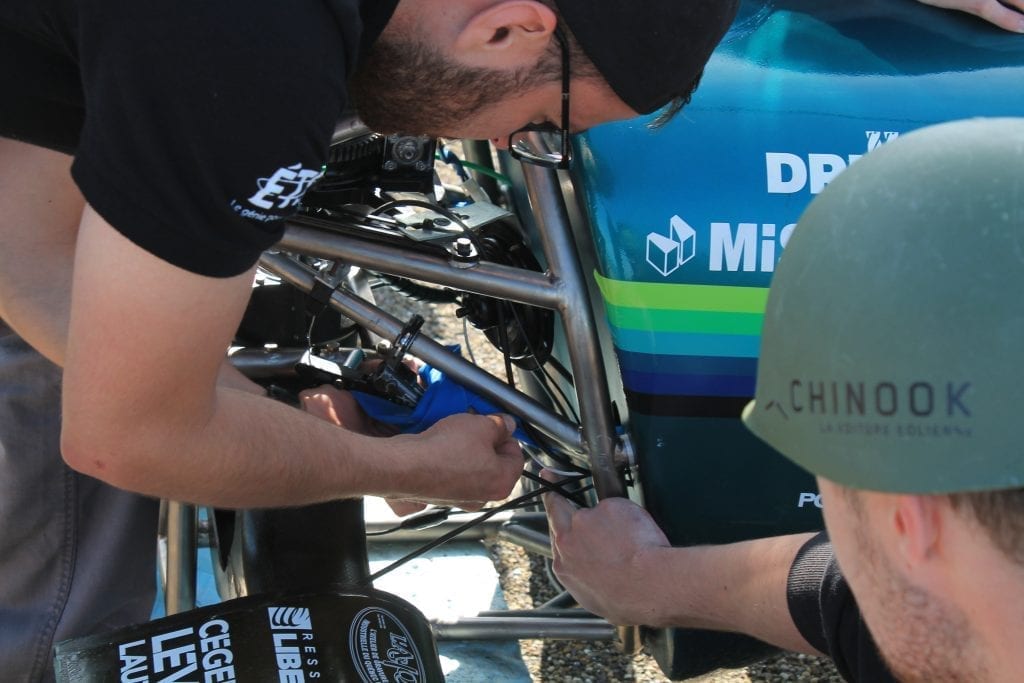 Chinook team making adjustments to the wheel frame of the wind-powered vehicle.