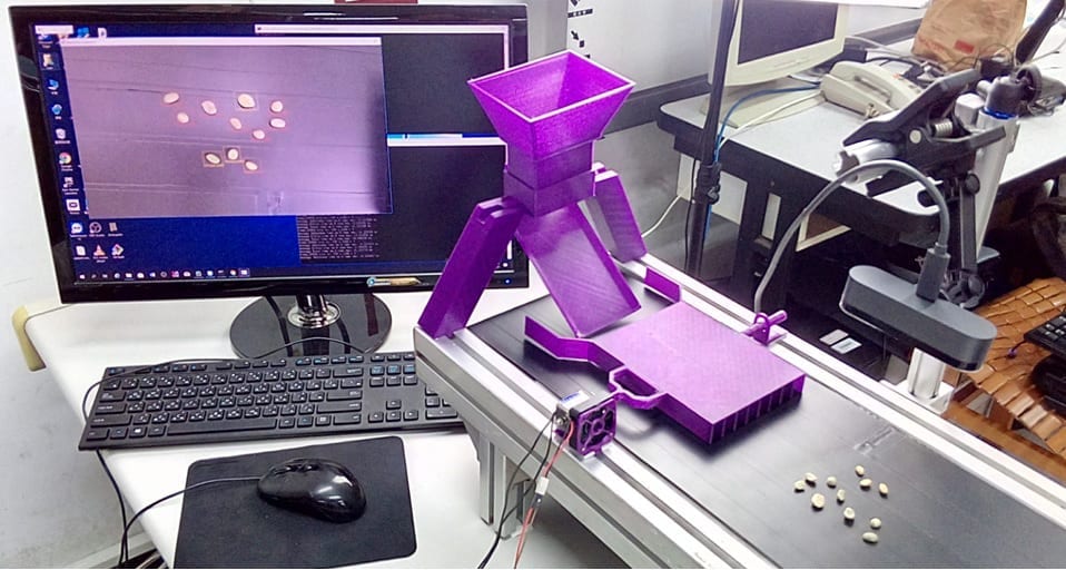 AI-driven coffee bean screening system in action with screen showing detailed scan.