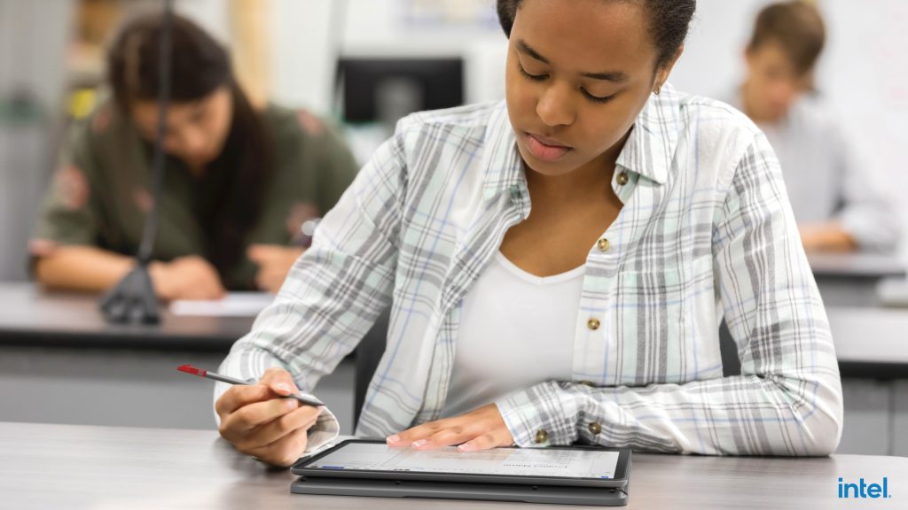 Student in a classroom using a Lenovo 500e Chromebook in tablet mode.