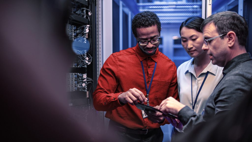 brand image - Professionals in a server room looking at a tablet.