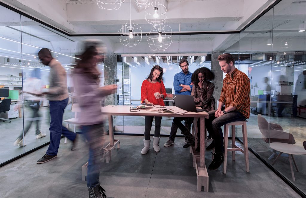 A diverse group of young professionals working on a project in a conference room.