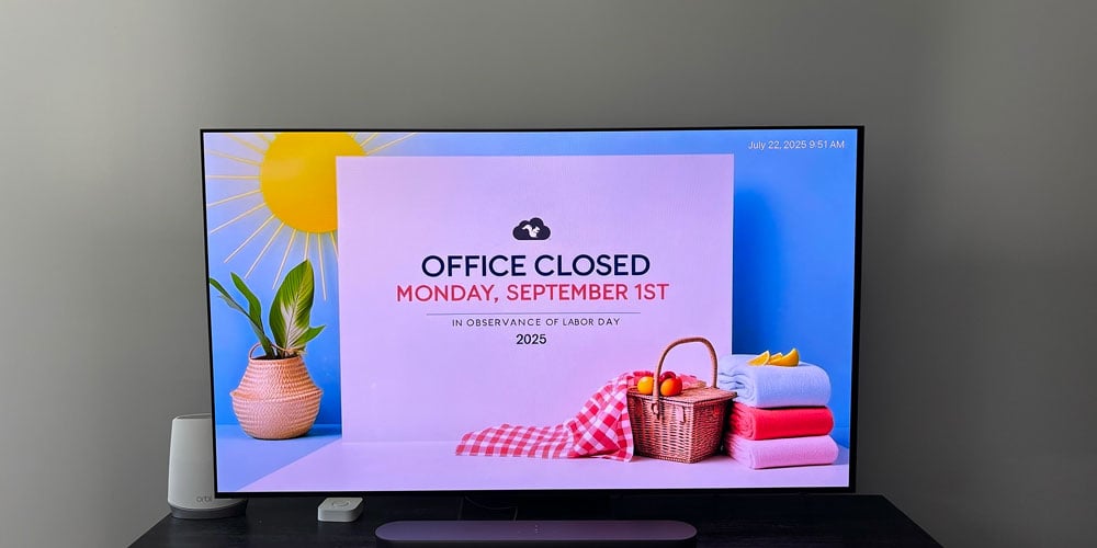 Digital signage on a TV announcing an office closure for Labor Day