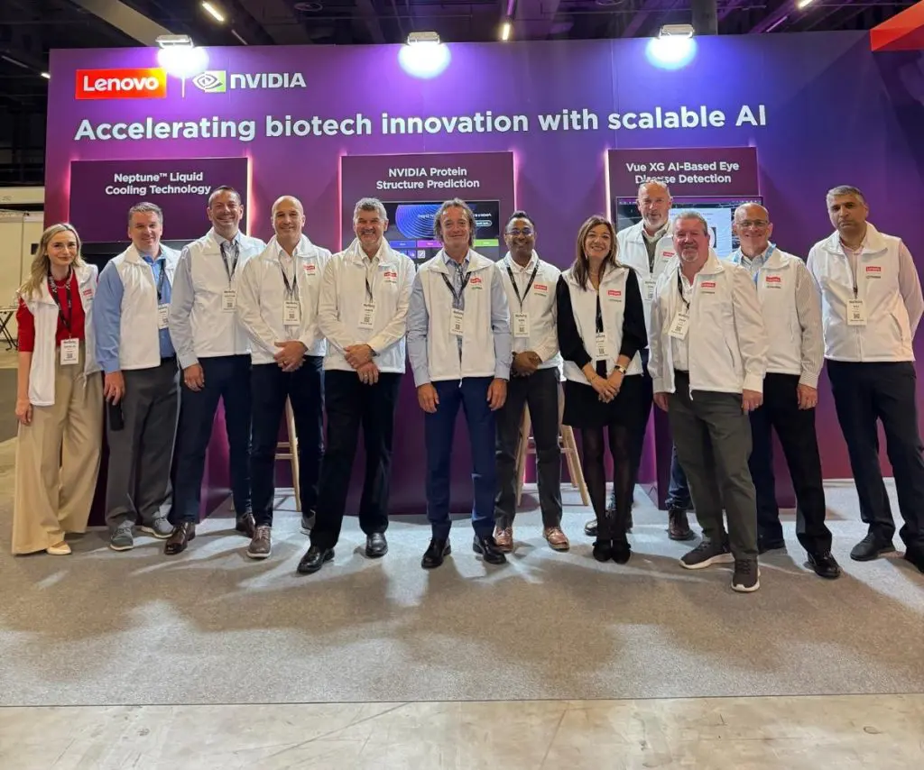 Lenovo team stood in a row in front of the purple sign and show floor booth.