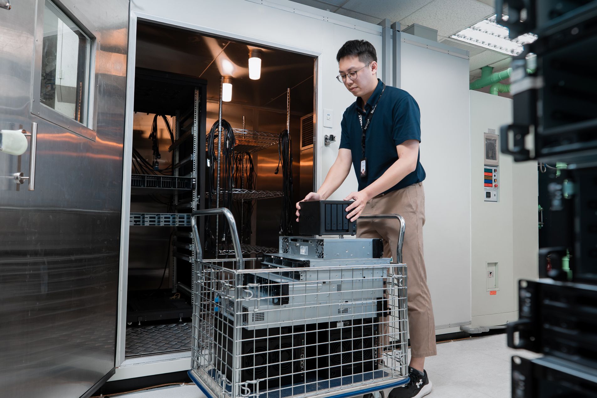 QA team unloading multiple Synology systems (DUT) into a heated chamber.